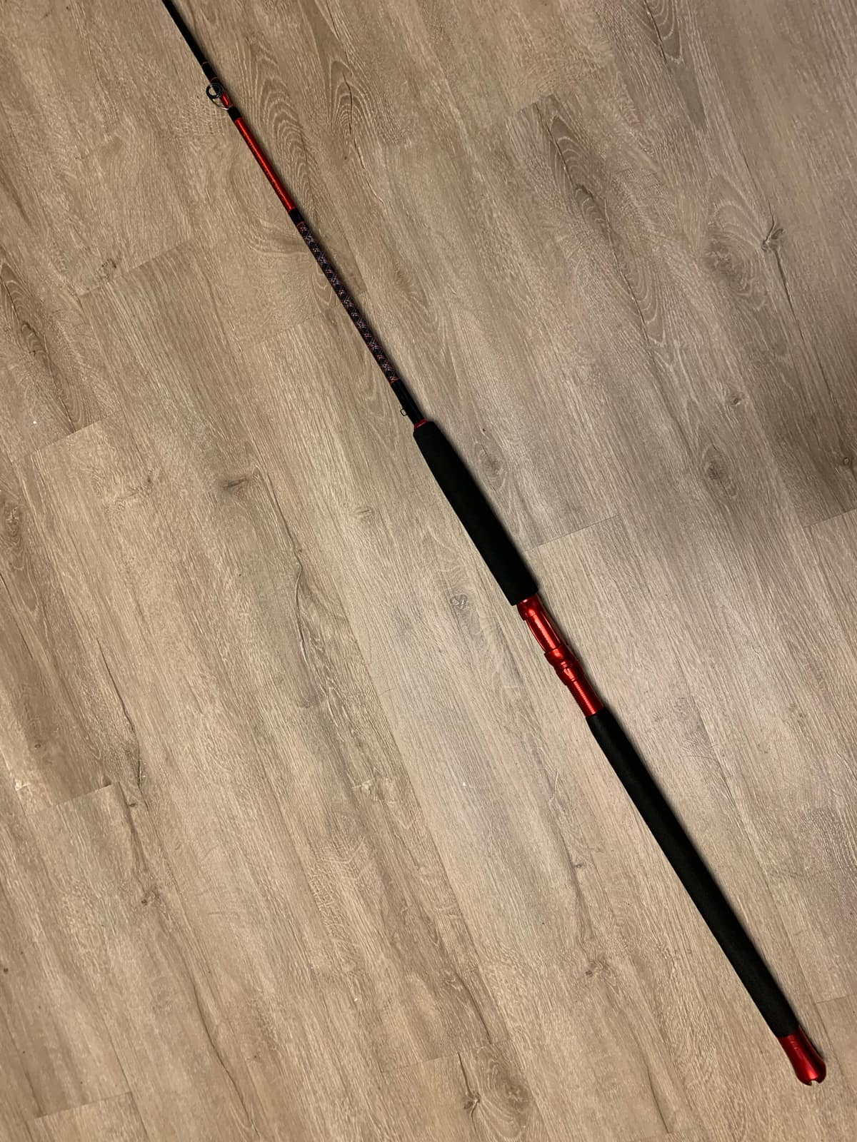 A finished custom rod standing against a plain background, full length visible