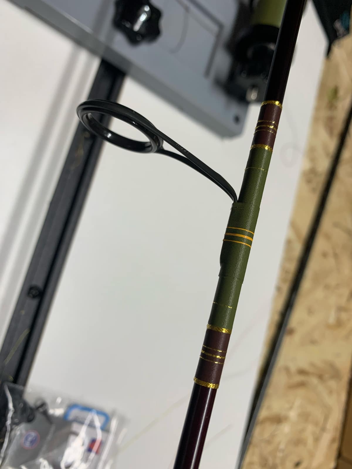 Close-up of a rod guide wrapped and finished, showing the thread-to-epoxy transition at the foot of the guide